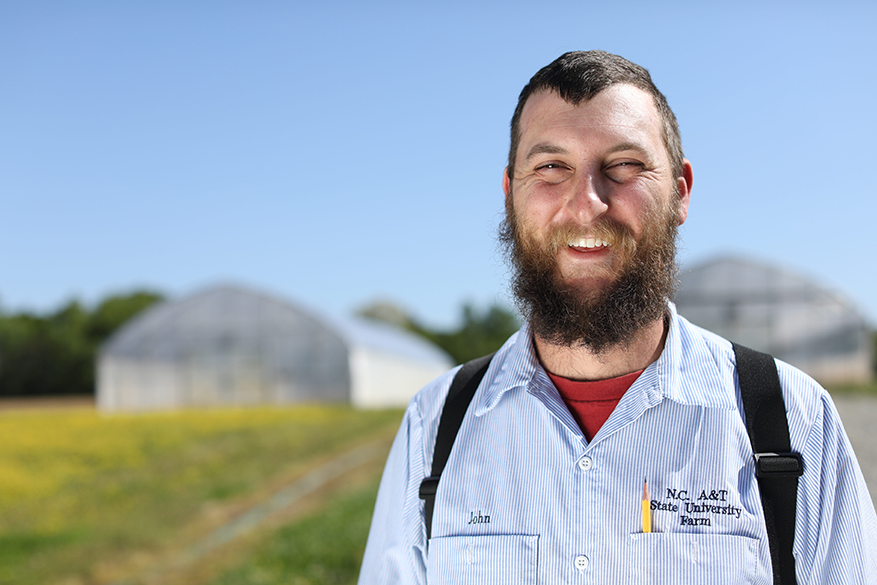 white man with beard on the Farm wearing the A&T Farm logo on his shirt
