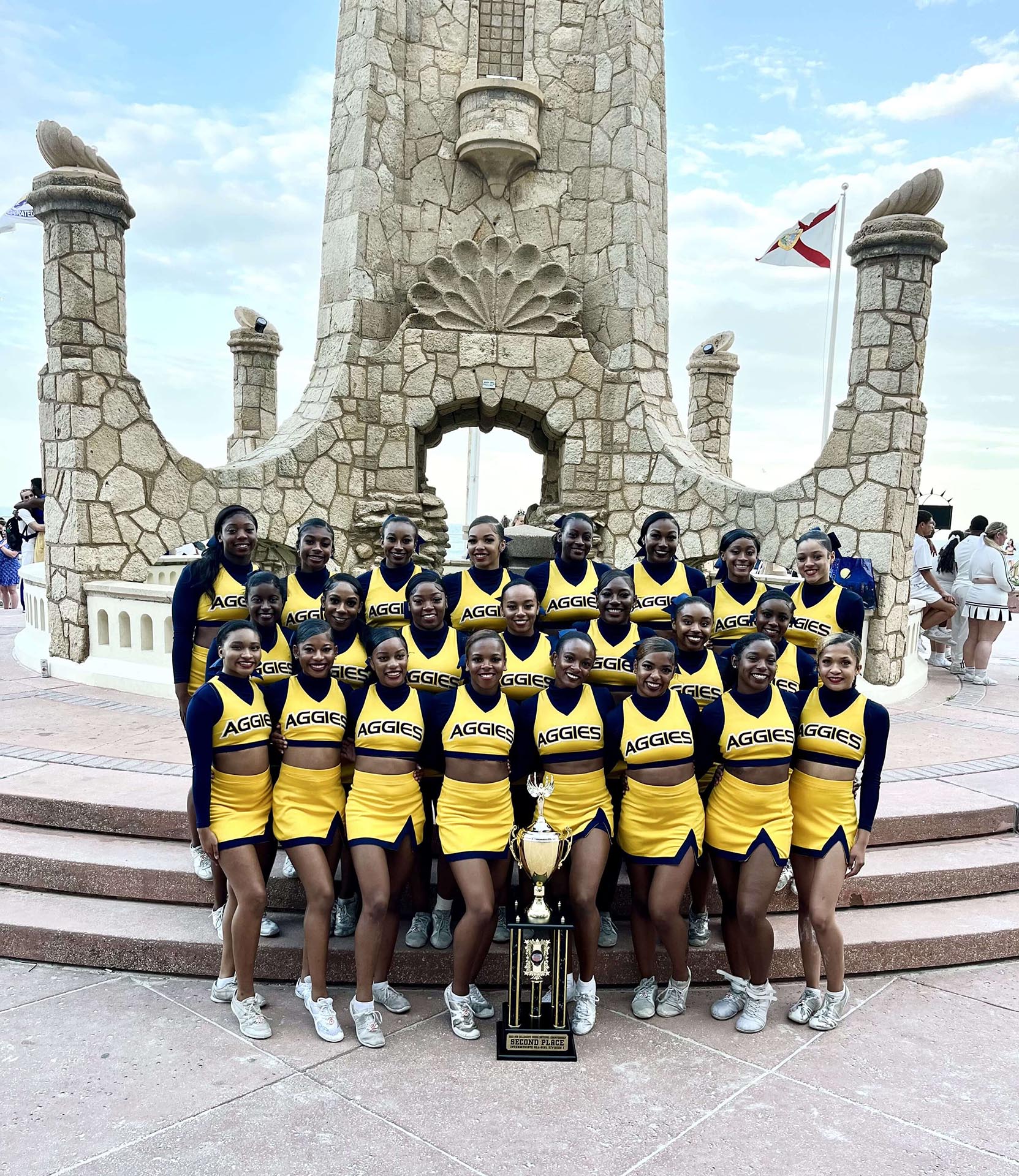 Aggie cheerleaders pose with trophy