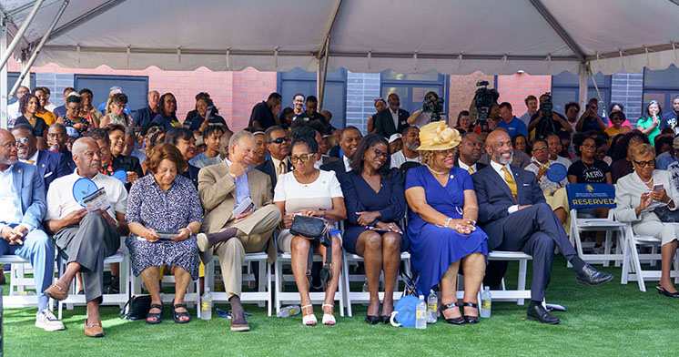 A crowd of people seated beneath a canopy in the Bluford Residence Hall courtyard