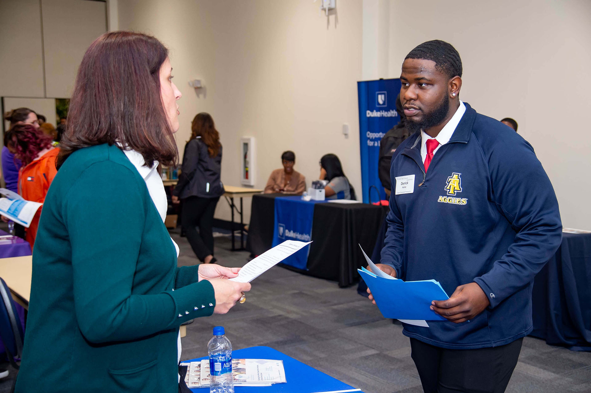 woman, left, talking with an A&T student, left, at a career fair